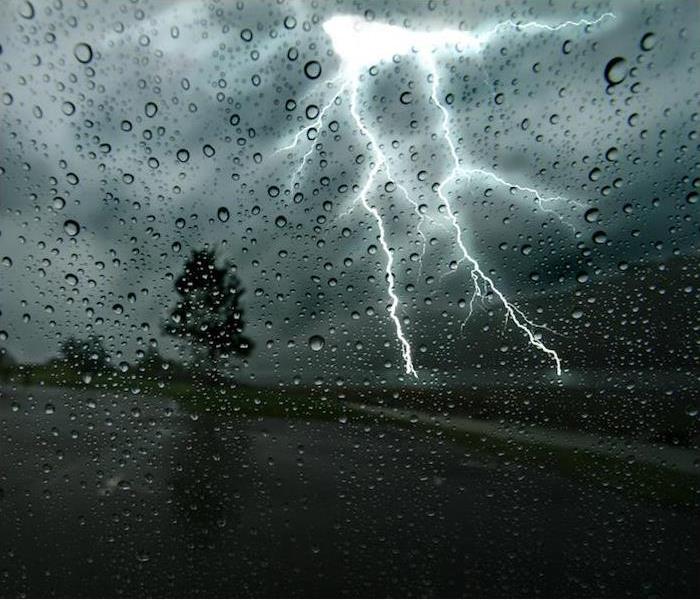 a large lightning strike just in front of person driving down road