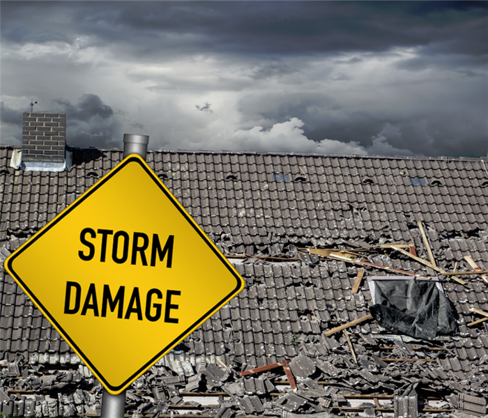 a storm damaged house with a sign in front of it saying storm damage